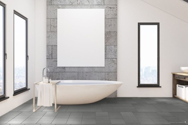 A bathroom with a tub and a poster on the wall with large bathroom tiles